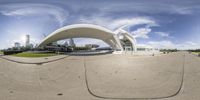 a fish eye photo showing the building and its surroundings in an open space with sky