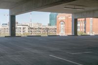 the floor and top is empty in this parking space with tall buildings in the background