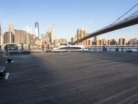 a bridge spanning across a wooden floor next to tall buildings and water in a harbor area