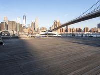 a bridge spanning across a wooden floor next to tall buildings and water in a harbor area