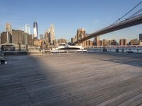 a bridge spanning across a wooden floor next to tall buildings and water in a harbor area