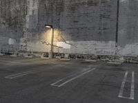 a concrete parking lot with a building in the back ground and street lights on top of it