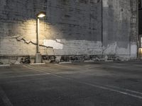 a concrete parking lot with a building in the back ground and street lights on top of it