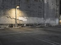 a concrete parking lot with a building in the back ground and street lights on top of it