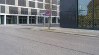 a city street with an empty street sign next to a building with a sign on it