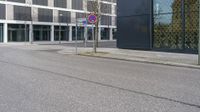 a city street with an empty street sign next to a building with a sign on it