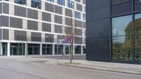 a city street with an empty street sign next to a building with a sign on it