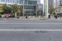 there is an empty street with cars driving in the background and buildings along both sides