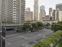 a view of an empty city from a skyscraper block across a street with parked cars