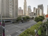 a view of an empty city from a skyscraper block across a street with parked cars