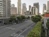 a view of an empty city from a skyscraper block across a street with parked cars