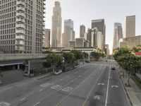 a view of an empty city from a skyscraper block across a street with parked cars