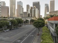 a view of an empty city from a skyscraper block across a street with parked cars