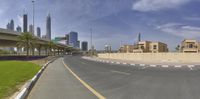 a road with an overpass and tall buildings behind it next to a parking lot