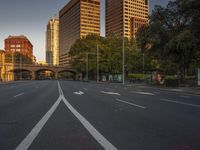 a city street with two lanes that go in opposite directions, and a bridge that is over it