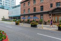 street scene with large flowered planters in front of buildings and a paved road