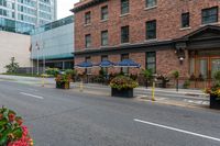 street scene with large flowered planters in front of buildings and a paved road