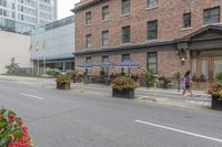 street scene with large flowered planters in front of buildings and a paved road