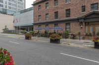 street scene with large flowered planters in front of buildings and a paved road