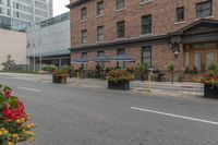 street scene with large flowered planters in front of buildings and a paved road