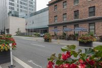 street scene with large flowered planters in front of buildings and a paved road