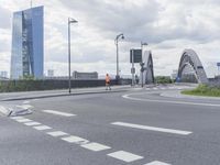 the intersection on a deserted day with cars passing by and buildings in the background and blue sky with clouds