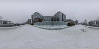 this image shows two large glass walls near each other in the snow and ice of a city