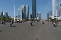 a group of people walking down the middle of a street near tall buildings in the background