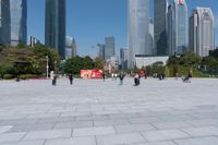 tall buildings with a blue sky in the background and people on the street on bicycles