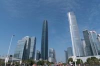 tall buildings with a blue sky in the background and people on the street on bicycles