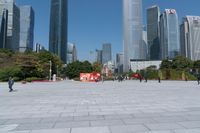 tall buildings with a blue sky in the background and people on the street on bicycles