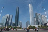 tall buildings with a blue sky in the background and people on the street on bicycles