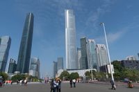 tall buildings with a blue sky in the background and people on the street on bicycles