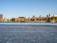 there is a woman that is standing with a skateboard by the water in the city