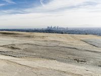 a person is sitting on top of a hill holding an umbrella and taking pictures of the view