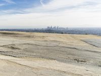 a person is sitting on top of a hill holding an umbrella and taking pictures of the view