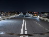 a city at night has lots of lights on it and on the street you can see traffic and bridge