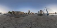 a fisheye view of city from across the riverbank of a harborfront area