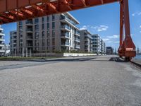 an industrial structure with a single pole on the ground near a street and two apartment buildings