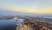 aerial view of a city by the water at dusk with buildings around the area and other buildings