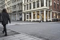 several large buildings line the city streets and a car is stopped at a traffic light