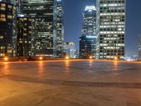 a city skyline at night with streetlights and illuminated buildings on the foreground and a fountain in the middle of the circle