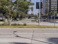 street view of a quiet city street with no traffic lights on it and tall buildings behind