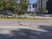 street view of a quiet city street with no traffic lights on it and tall buildings behind