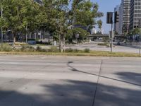 street view of a quiet city street with no traffic lights on it and tall buildings behind