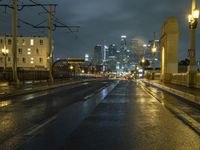 cityscape in the night, with street lights on and rain in the street