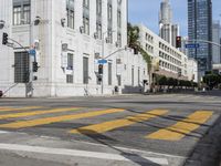 two cyclists riding down the street next to a stoplight on either side of the street