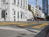 two cyclists riding down the street next to a stoplight on either side of the street