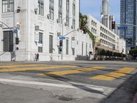 two cyclists riding down the street next to a stoplight on either side of the street