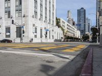 two cyclists riding down the street next to a stoplight on either side of the street